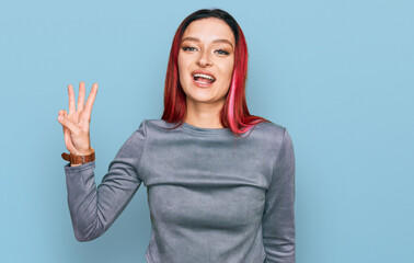 Young caucasian woman wearing casual clothes showing and pointing up with fingers number three while smiling confident and happy.