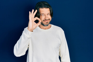 Middle age caucasian man wearing casual clothes smiling positive doing ok sign with hand and fingers. successful expression.