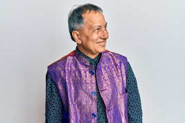 Fototapeta premium Middle age indian man wearing traditional indian clothes looking to side, relax profile pose with natural face and confident smile.