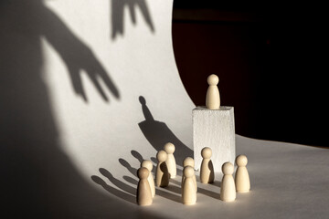 The man on the orator's pedestal is manipulated with a hand from above. Manipulation concept
