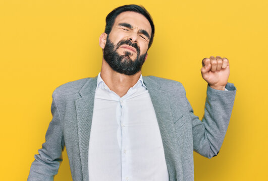 Young hispanic man wearing business clothes stretching back, tired and relaxed, sleepy and yawning for early morning