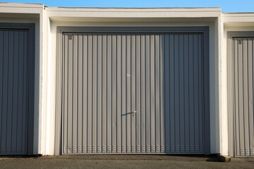 close up of a blue closed garage door in a parking area
