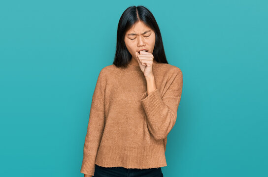 Beautiful young asian woman wearing casual winter sweater feeling unwell and coughing as symptom for cold or bronchitis. health care concept.