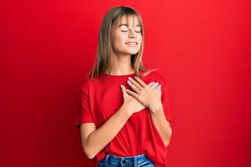 Teenager caucasian girl wearing casual red t shirt smiling with hands on chest, eyes closed with grateful gesture on face. health concept.