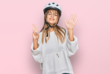 Teenager caucasian girl wearing bike helmet showing and pointing up with fingers number eight while smiling confident and happy.