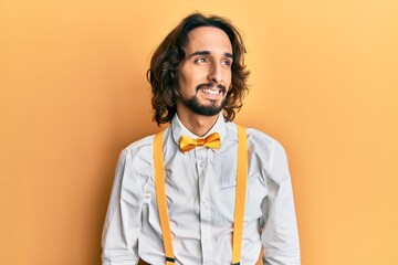Young hispanic man wearing hipster elegant look looking away to side with smile on face, natural expression. laughing confident.