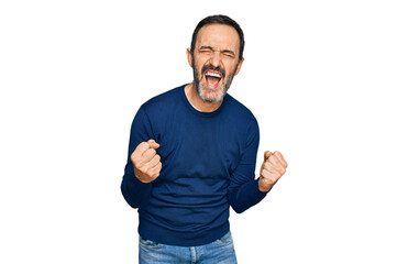 Naklejka premium Middle age hispanic man wearing casual clothes very happy and excited doing winner gesture with arms raised, smiling and screaming for success. celebration concept.