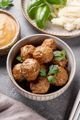 Traditional swedish meatballs with creamy sauce and mashed potatoes on gray table close up vertical photo