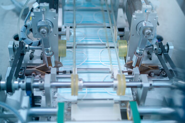 Close up of machine producing surgical mask in modern factory, Covid-19 protection and medical...