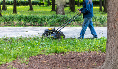 A lawnmower is cutting the grass