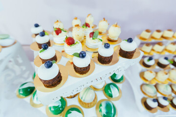 Candy bar. White festive table with deserts, strawberry tartlet and cupcakes. Wedding. Reception Tartlets