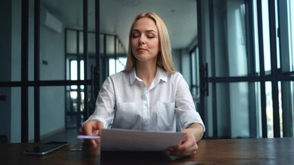 Middle shot portrait of serious blonde business woman working with document and talking on video call. Webcam view of female hr recruitment manager talking with candidate during distance interview.