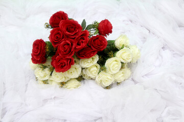 red roses and white roses on a white cloth