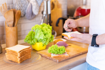 man making sandwich on the kitchen