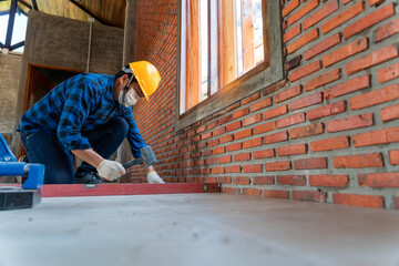 artisan tiler hands working on a new house entrance, local and professional handyman applying tiles at construction site