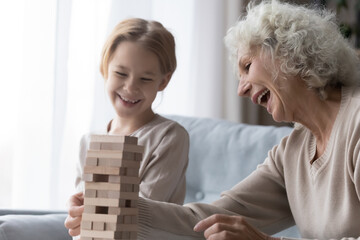 Your move, granny. Laughing senior grandmother enjoy playing board game with beloved little...