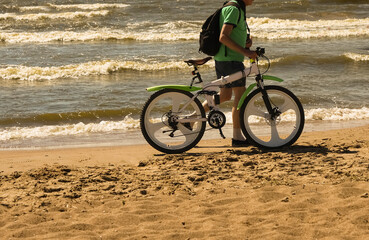 Senior caucasian man with BMW bicycle walking on the beach. travel vacation retirement lifestyle concept