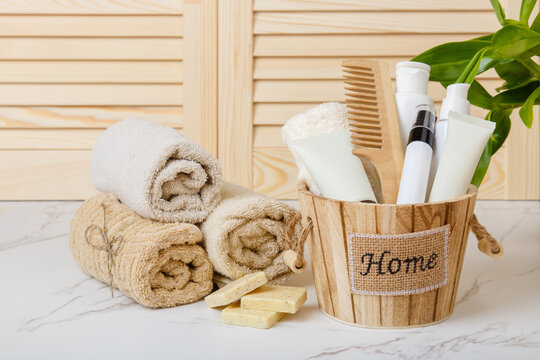 Natural Soap, towels and bath oil, bodycare products on background of bathroom wooden louvered doors. Home spa. Everyday hygiene. Eco-friendly hair care products. Natural cosmetics. Shower gel