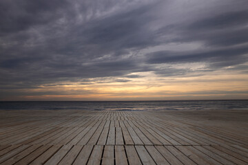 Fototapeta na wymiar Imagen de una playa con unas tarimas de madera y al fondo un amanecer precioso