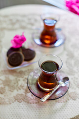 Tea in traditional Turkish glass tea glasses on the table with cookies