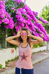 Beautiful young girl model brunette posing with blooming purple flowers in Turkey on the island of Buyukada