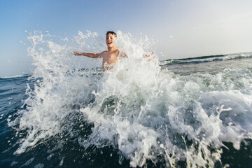 Happy child playing in the sea. Kid having fun outdoors. Summer vacation and healthy lifestyle concept. Selective focus