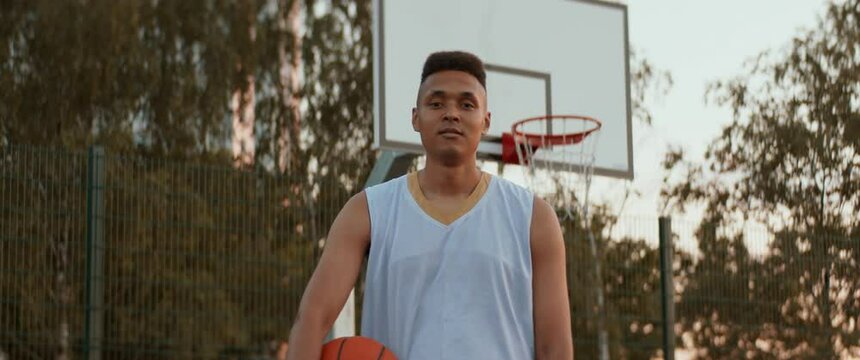 Portrait of Black African American young adult male posing on an outdoor basketball court. Shot with 2x anamorphic lens