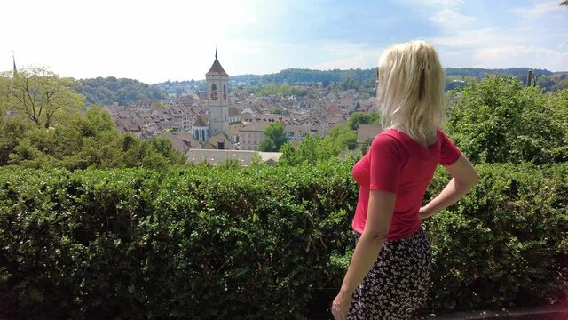 Woman looking at the panorama of Schaffhausen Swiss historic town in Switzerland. Lookout of terraced vineyards with cityscape aerial view on the river Rhine. Swiss capital of canton Schaffhausen.