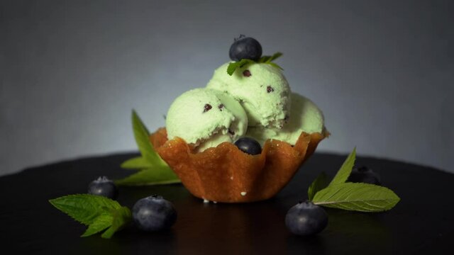 Melting mint ice cream chocolate bites blueberry decorated dessert waffle, 4K