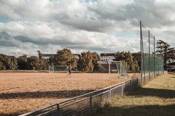 Paris, France 04-07-2021: a boy plays football alone in a field