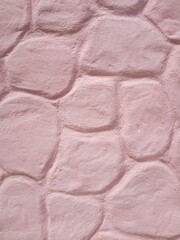 pink cement wall in huge stones, plaster background
