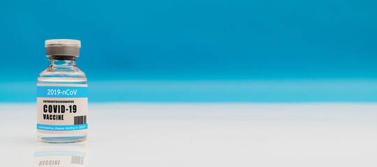 Coronavirus Covid-19 vaccine concept - small glass vial with silver cap on white table