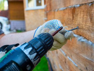 a beginner tries to use an electric screwdriver to screw a nail into the wall. Errors in the use of...