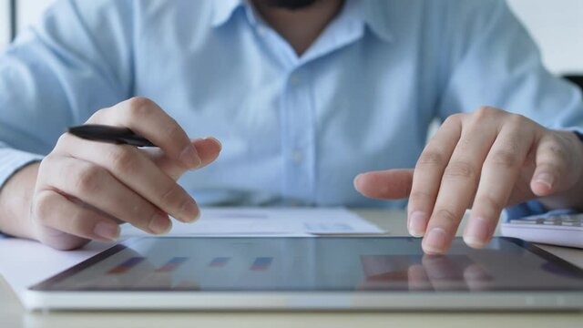 slow motion scene businessman hand  pointing in dashboard statistic chart on digital tablet screen in office room to planning or analyzing the company's profit or business strategy concept