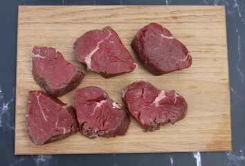 Frisches, saftiges Rinderfilet vom Freilandrind zu Medallions geschnitten auf einem Holzbrett.