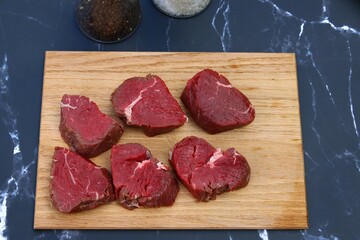 Frisches, saftiges Rinderfilet vom Freilandrind zu Medallions geschnitten auf einem Holzbrett.