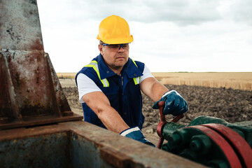 Oil worker is turning valve on the oil pipeline. Oil and Gas Industry. 