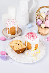Easter cake with raisins in sugar glaze. festive pastries with pink sprinkles, painted eggs, pussy willow and Easter decor on a white background. religious holiday 
