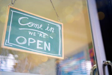 Text on vintage black sign. Welcome open sign on shop door .vintage tone stye.