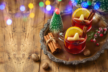 Christmas mulled red wine with spices and Christmas decorations on wooden table. Happy holidays greeting card.