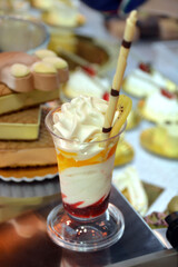 copa de helado cremoso de nata y frutas cítricas con palito de galleta y chocolate