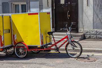 Red cargo bike with a large yellow container
