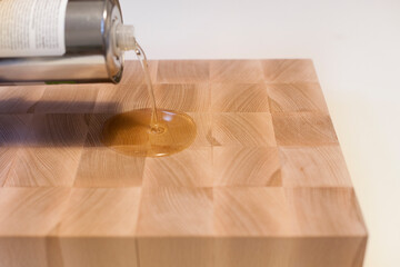 Auftragen von Holzpflegeöl auf ein Lebensmittelschneidebrett. Applying wood care oil on a food...