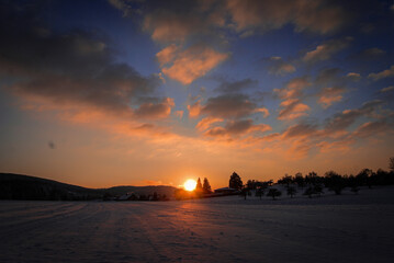 Naklejka na ściany i meble Sonnenuntergang über Schneelandschaft