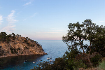 Fototapeta na wymiar Remote and wild Mediterranean beach with boats