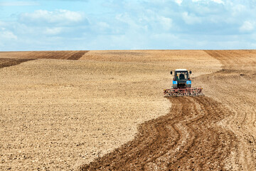 Obraz premium an old tractor plows the soil