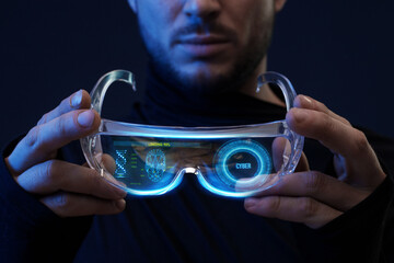 Man with futuristic tablet in hand. Guy using VR glasses. Augmented reality, future technology concept. Blue neon light. Futuristic holographic interface to display data.