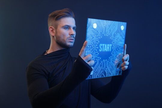 Man presses the start button. Guy using VR helmet. Augmented reality, future technology, game concept. Blue neon light. Futuristic holographic interface to display data.