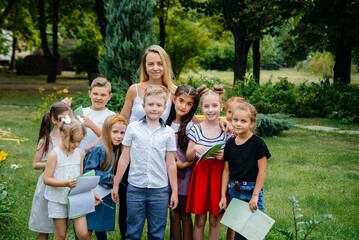 Fototapeta premium A teacher teaches a class of children in an outdoor Park. Back to school, learning during the pandemic