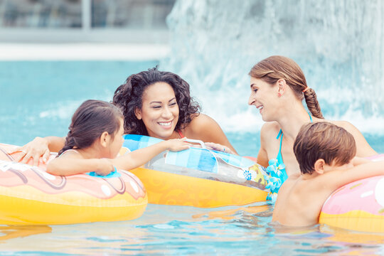 Happy family enjoying in swimming pool at waterpark